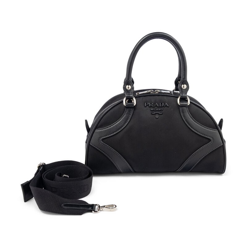 PRADA, SMALL NYLON BOWLING BAG: PRADA, SMALL NYLON BOWLING BAG Small bowling bag in black nylon with black leather trim. Double zipper closure, rolled leather handles, and removable woven nylon strap. Label: Prada Style/Serial