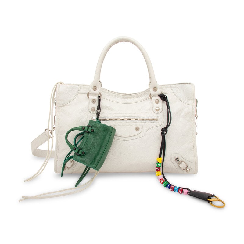 BALENCIAGA, WHITE MEDIUM CITY BAG WITH CHARMS: BALENCIAGA, WHITE MEDIUM CITY BAG WITH CHARMS Medium City bag in white aged calfskin leather. Zipper closure and rolled and braided handles, and removable flat leather shoulder strap. Includes