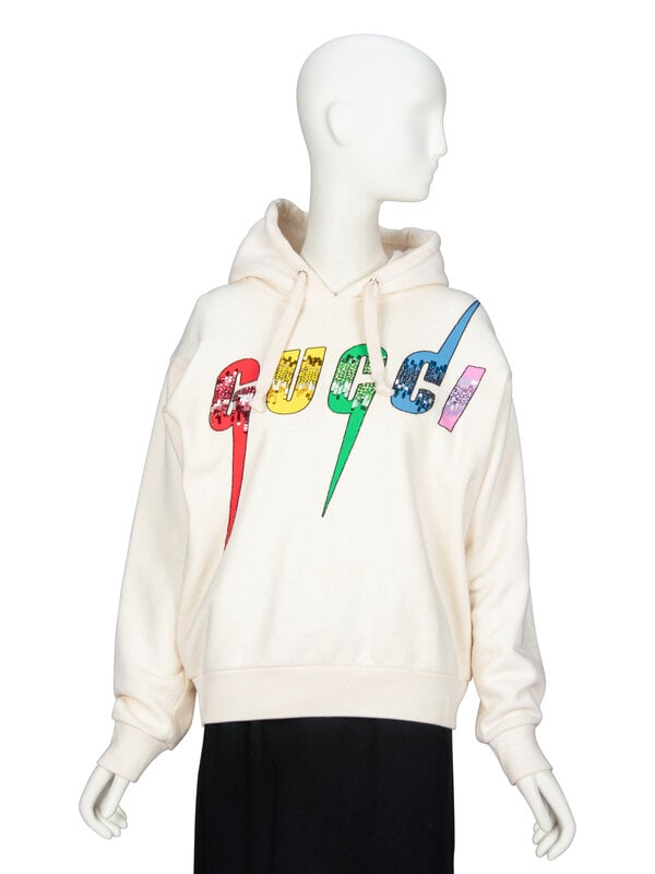 GUCCI, EMBELLISHED LOGO HOODIE: GUCCI, EMBELLISHED LOGO HOODIE Hoodie in cream cotton French terry. Hood with tonal woven drawstrings. Dropped shoulder seams and full-length sleeves with ribbed knit cuffs. Painted Gucci logo with