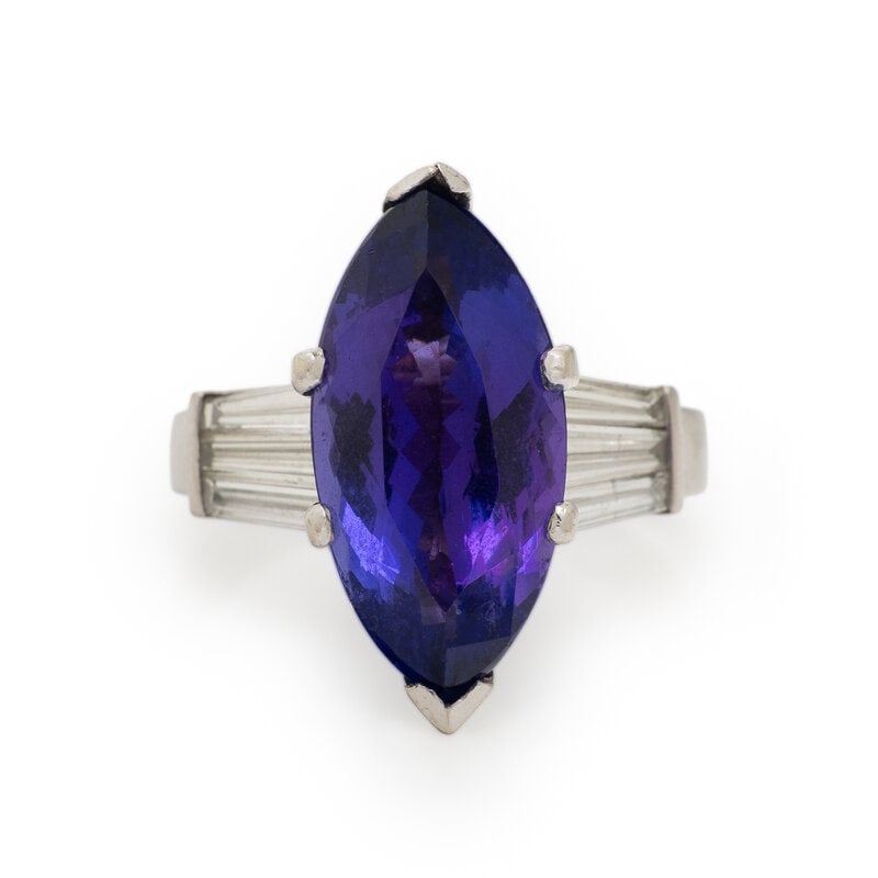 PLATINUM, TANZANITE AND DIAMOND RING: PLATINUM, TANZANITE AND DIAMOND RING Marquise shaped tanzanite measuring approximately 18.40 x 9.00 mm, and tapered baguette cut diamonds weighing approximately 0.90 carat total. Platinum. Ring size