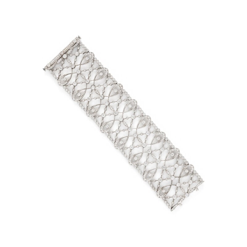 WIDE WHITE GOLD AND DIAMOND BRACELET: WIDE WHITE GOLD AND DIAMOND BRACELET Round diamonds weighing approximately 9.00 carats total. 18 karat white gold. 6 3/8 inches long, 1 1/2 inches wide. Stamp: 750 (partially obscured maker's mark).