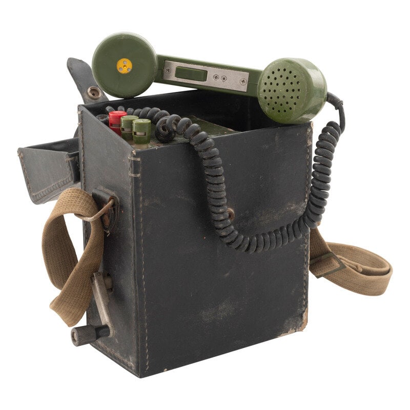 Chinese Field Phone: Chinese Field Phone 9" x 7.5" x 4.25" Imitation leather case with canvas carrying strap containing a green painted and plastic battery housing and magneto, with removable hand crank to the side.