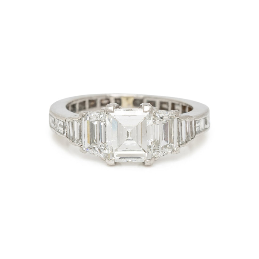 DIAMOND AND PLATINUM RING: DIAMOND AND PLATINUM RING Featuring a cut-cornered rectangular step cut diamond weighing 1.38 carats, flanked by trapezoidal and baguette cut diamonds weighing approximately 0.75 carat total, the