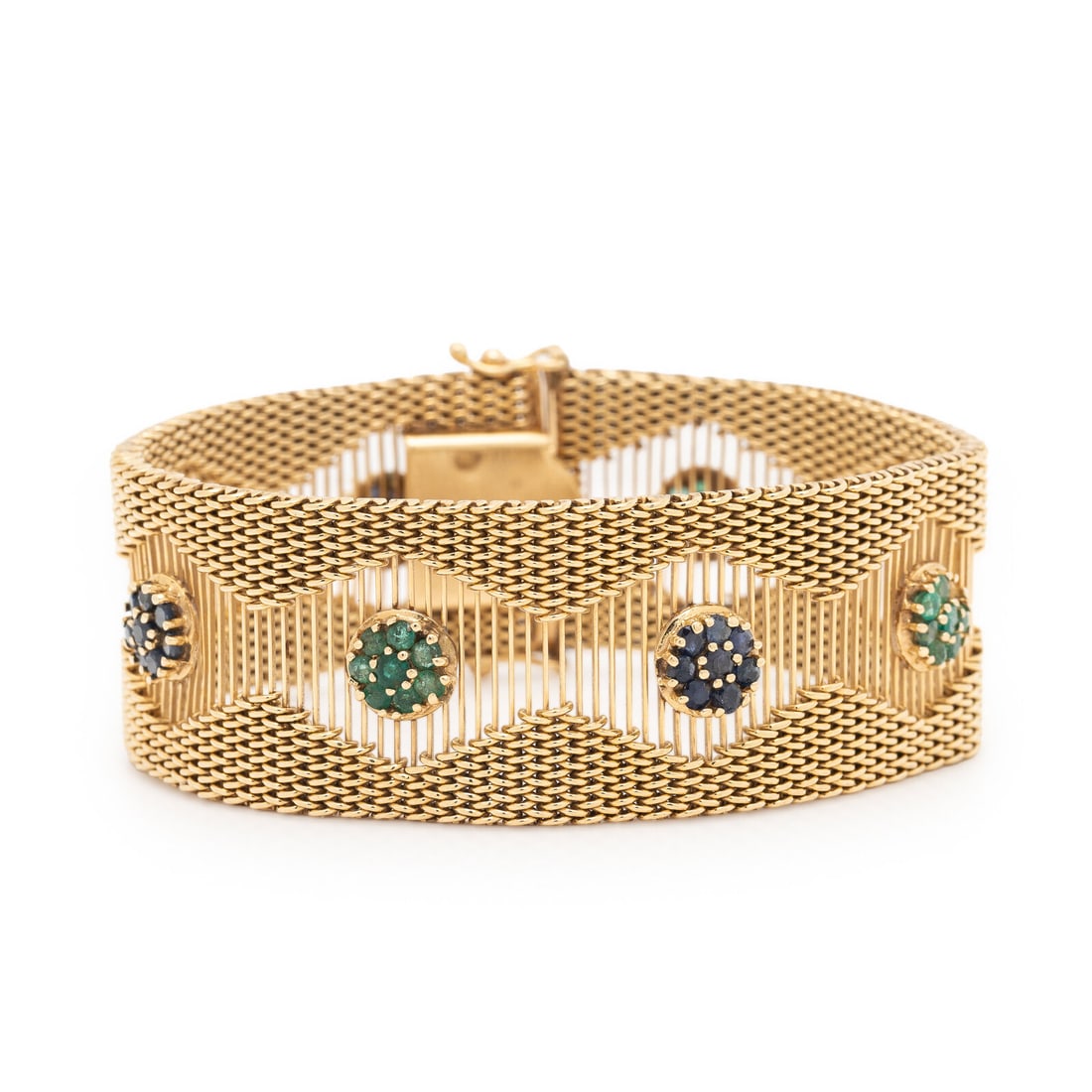 YELLOW GOLD, EMERALD, AND SAPPHIRE BRACELET: YELLOW GOLD, EMERALD, AND SAPPHIRE BRACELET In a flexible openwork design, set with clusters of round emeralds and sapphires. Mounted in 14 karat yellow gold. 7 inches long, 7/8 inch wide. Stamp: 14K