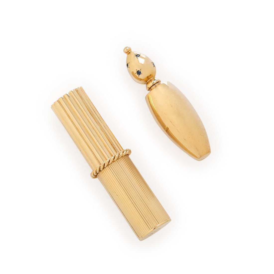 CARTIER, YELLOW GOLD LIPSTICK CASE AND UNSIGNED PERFUME BOTTLE: CARTIER, YELLOW GOLD LIPSTICK CASE AND UNSIGNED PERFUME BOTTLE Including a lipstick case and a perfume bottle, the top of which is set with round sapphires. Mounted in 14 karat yellow gold. Lipstick