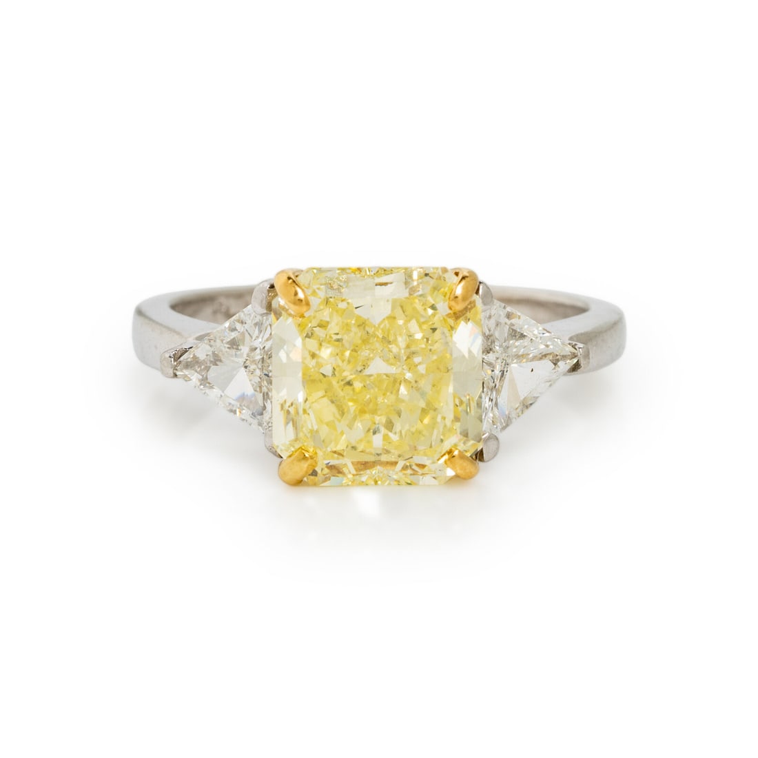 FANCY YELLOW DIAMOND, DIAMOND, AND PLATINUM RING: FANCY YELLOW DIAMOND, DIAMOND, AND PLATINUM RING Featuring a radiant cut fancy yellow diamond weighing 3.26 carats, flanked by two trillion cut diamonds weighing approximately 0.85 carat total.