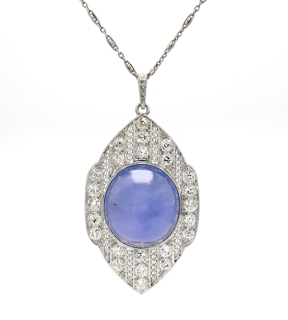 ART DECO, CEYLON STAR SAPPHIRE AND DIAMOND PENDANT NECKLACE: ART DECO, CEYLON STAR SAPPHIRE AND DIAMOND PENDANT NECKLACE Featuring an oval cabochon star sapphire weighing approximately 44.95 carats by formula set in a milgrain and filigree design, surrounded