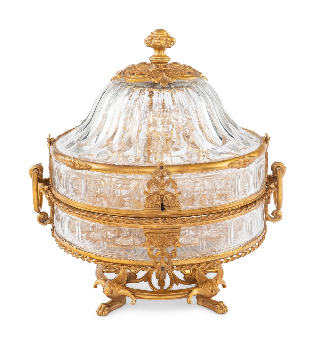 A Baccarat Gilt Bronze Mounted and Cut Glass Cave à Liqueur: A Baccarat Gilt Bronze Mounted and Cut Glass Cave à Liqueur 19th Century the interior caddy with four decanters and sixteen cordial glasses. Overall height 15 x width over handles 14 inches. Prop