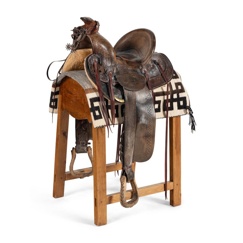 A High-Backed Western Saddle, by Miles City Saddlery: A High-Backed Western Saddle, by Miles City Saddlery tooled with a scrolling floral pattern. on a custom stand with a saddle blanket. Saddle height 18 x length 23 x width 18 inches; seat size 13
