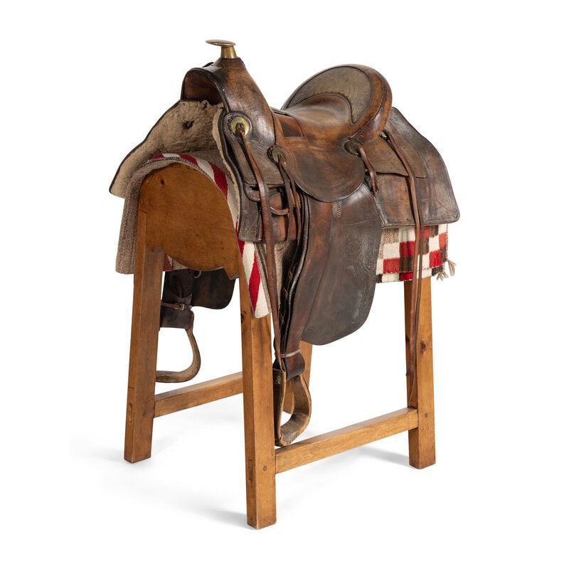 A Western Ranch Saddle, by R.T. Fraser, Colorado: A Western Ranch Saddle, by R.T. Fraser, Colorado featuring a brass horn and conchas; stamping design along the edges; on a custom stand with a saddle blanket. Saddle height 19 x length 27 1/2 x
