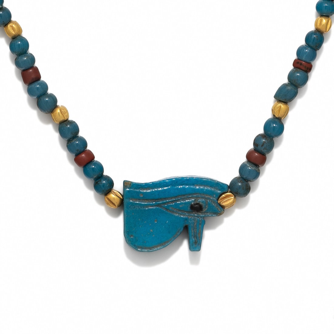 An Egyptian Faience, Gold, Red Jasper, and Blue Glass Necklace with a Wadjet Eye: An Egyptian Faience, Gold, Red Jasper, and Blue Glass Necklace with a Wadjet Eye Late Period, 26th-30th Dynasty, 664-343 B.C. Length 44.5 cm (17 1/2 inches); High karat gold; 13.81 grams. Property