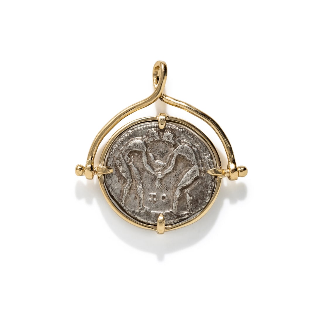 A Greek Silver Tetradrachm with Two Wrestlers: A Greek Silver Tetradrachm with Two Wrestlers Set in a gold pendant Aspendos, Pamphylia, Circa 370-333 B.C. Height of pendant 3.4 cm (1 3/8 inches); 14 karat gold; 14.36 grams. Provenance: Lee