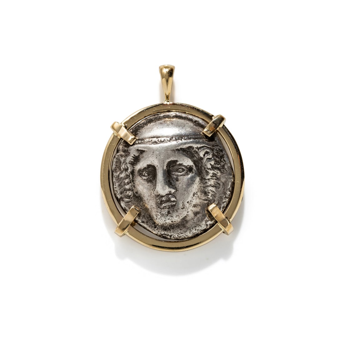 A Greek Silver Tetradrachm with the Head of Hermes: A Greek Silver Tetradrachm with the Head of Hermes Set in a gold pendant Ainos, Circa 401-356 B.C. Height of pendant 3.4 cm (1 3/8 inches); 14 karat gold; 17.66 grams. Provenance: Lee Kieffer