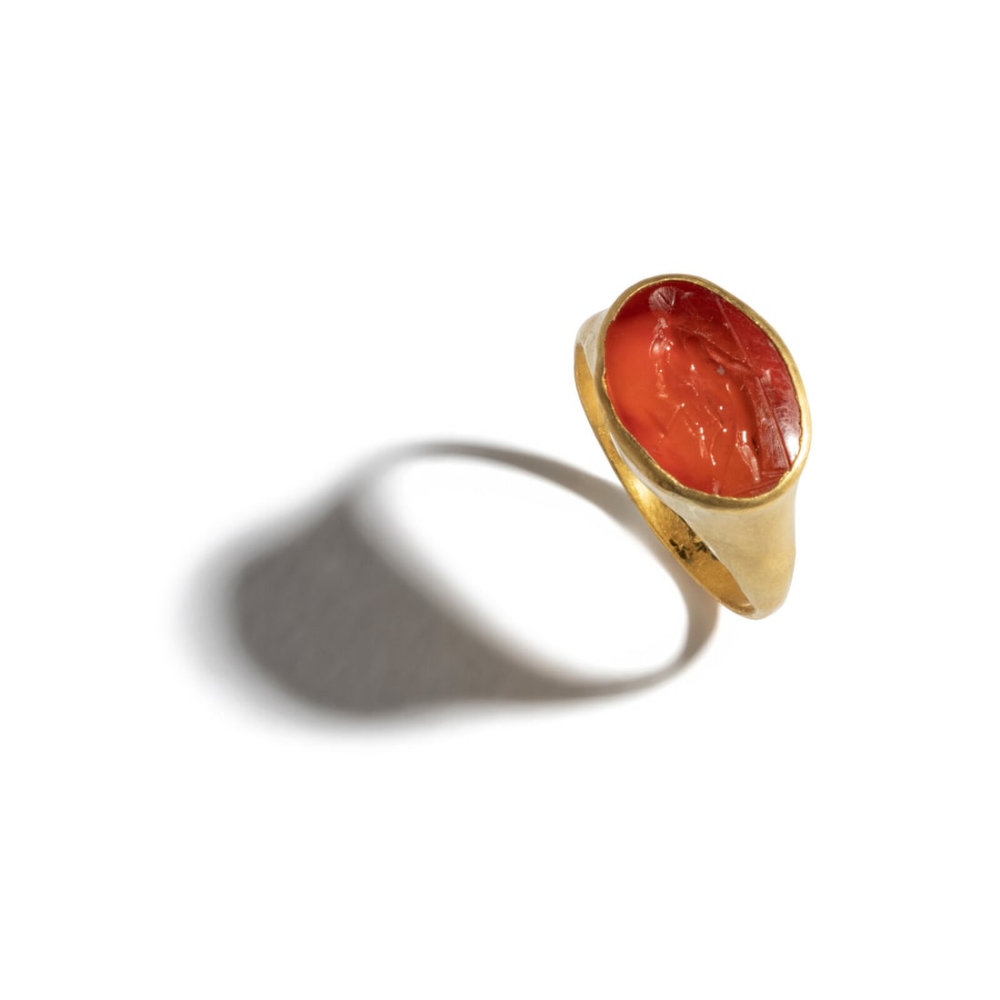 A Roman Gold and Carnelian Finger Ring with a Male Standing Figure: A Roman Gold and Carnelian Finger Ring with a Male Standing Figure Circa 3rd Century A.D. Height 2.3 cm (7/8 inch); Ring size 4 3/4; High karat gold; 3.09 grams. Provenance: Private Collection, New Yo