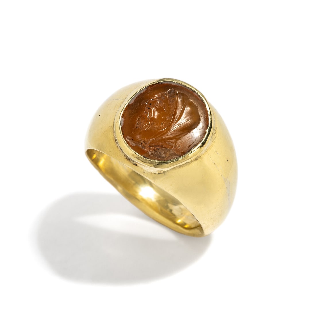 A Roman Carnelian Ring Stone with the Emperor Hadrian as Pontifex Maximus: A Roman Carnelian Ring Stone with the Emperor Hadrian as Pontifex Maximus Set in a gold ring Circa 2nd Century A.D. Height 2.6 cm (1 inch); Ring size 8 1/4; High karat gold; 15.74 grams. Provenance: