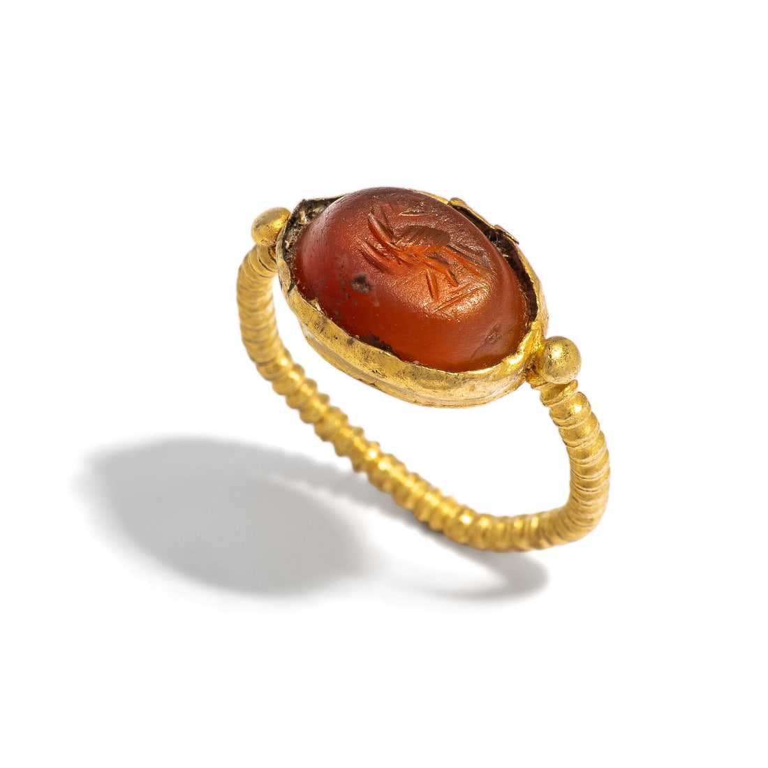 A Roman Gold and Carnelian Finger Ring with an Eagle: A Roman Gold and Carnelian Finger Ring with an Eagle Circa 3rd Century A.D. Height 2.4 cm (1 inch); Ring size 6 1/2; High karat gold; 3.71 grams. Provenance: Private Collection, Bergen County, New