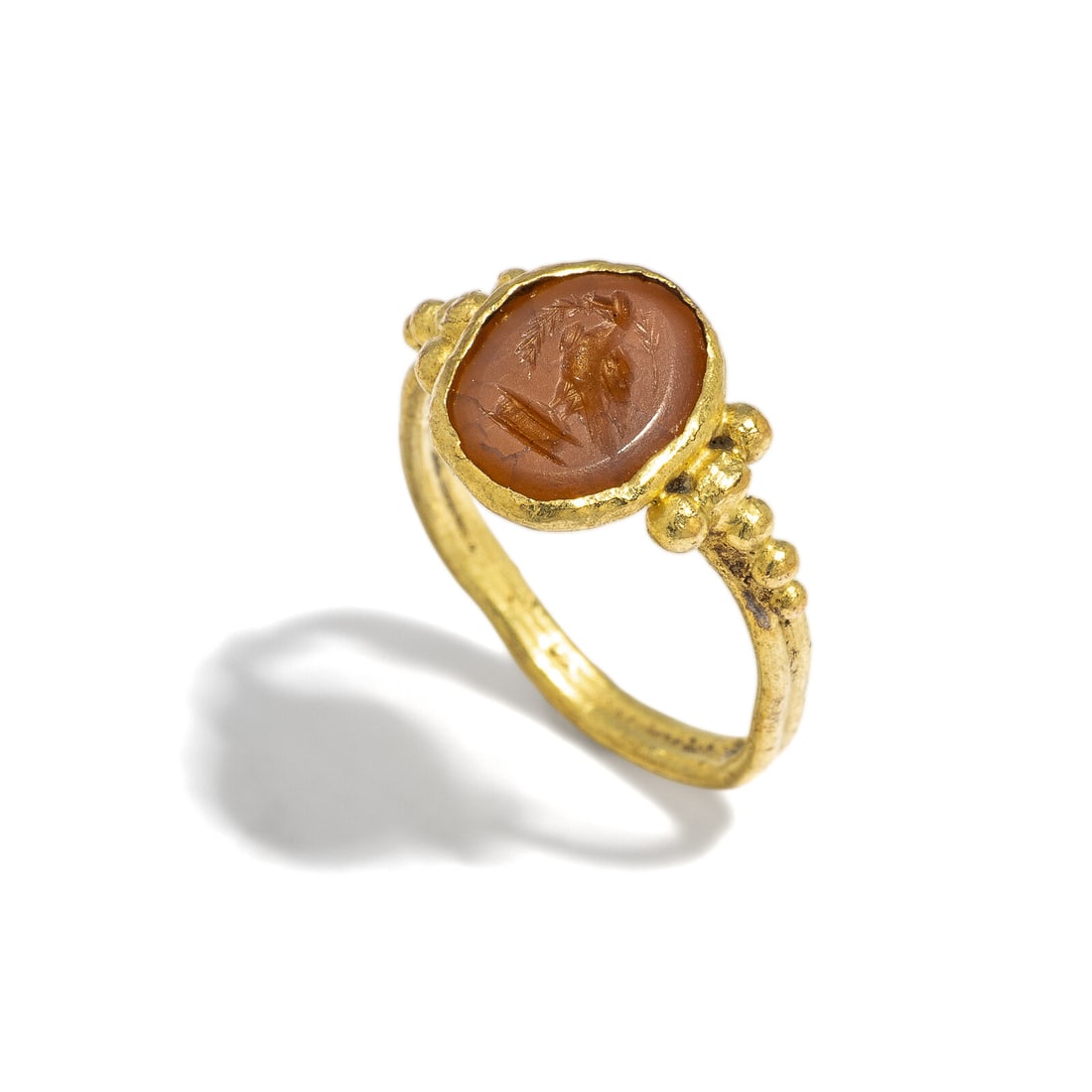 A Roman Gold and Carnelian Finger Ring with an Eagle: A Roman Gold and Carnelian Finger Ring with an Eagle Circa 1st-3rd Century A.D. Height 2 cm (3/4 inch); Ring size 4; High karat gold; 2.39 grams. Provenance: Private Collection, Bergen County, New