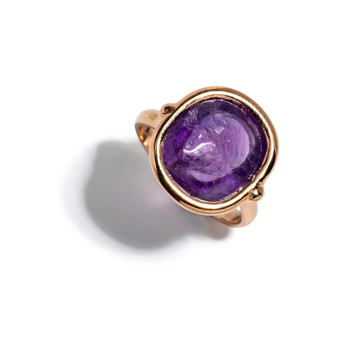 A Roman Amethyst Intaglio with the Portrait Head of a Boy: A Roman Amethyst Intaglio with the Portrait Head of a Boy Set in a rose gold ring Circa 1st Century B.C. Height 2.2 cm (7/8 inch); Ring size 6; 14 karat gold; 4.31 grams. Provenance: Private