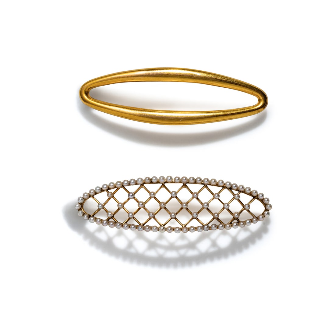 ANTIQUE, TWO YELLOW GOLD BARRETTES: ANTIQUE, TWO YELLOW GOLD BARRETTES Including two barrettes, one set with seed pearls. Yellow gold. Both 2 3/8 x 5/8 inches. Gross weight: 9.25 dwt. Property from the Estate of Mrs. Joan S. Kanof, New