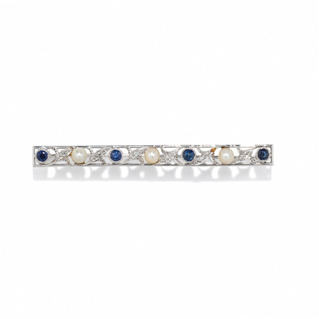 LEBOLT, EDWARDIAN, DIAMOND, SAPPHIRE, AND CULTURED PEARL BAR BROOCH: LEBOLT, EDWARDIAN, DIAMOND, SAPPHIRE, AND CULTURED PEARL BAR BROOCH Round sapphires, cultured pearls, and old European cut diamonds. 18 karat white gold. 2 5/8 inches long. Stamp: 14K LEBOLT. Gross