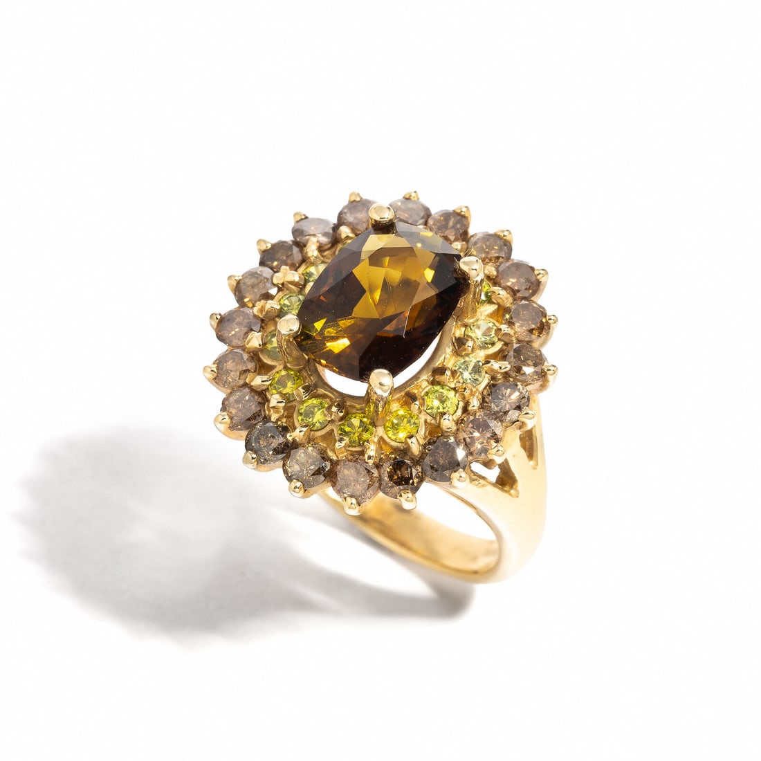 TOURMALINE AND COLORED DIAMOND RING: TOURMALINE AND COLORED DIAMOND RING Oval tourmaline weighing approximately 4.20 carats total, round green garnets, and brown diamonds (origin of color not tested) weighing approximately 1.25 carats to