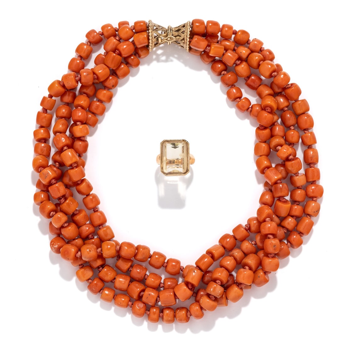 CORAL BEADED NECKLACE AND YELLOW GOLD AND CITRINE RING: CORAL BEADED NECKLACE AND YELLOW GOLD AND CITRINE RING Including a coral beaded necklace with four strands of coral beads measuring approximately 5.20 - 7.10 mm x 6.70 - 7.70 mm, and a ring set with a