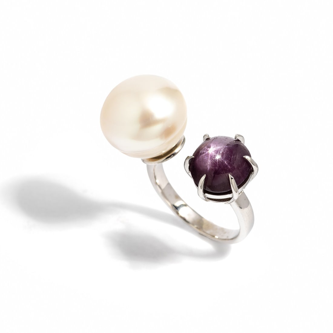 STAR RUBY AND CULTURED PEARL RING: STAR RUBY AND CULTURED PEARL RING Cultured pearl and oval double cabochon star ruby weighing 5.01 carats. 14 karat white gold. Ring size 5 3/4. Stamp: 14K. Gross weight: 4.75 dwt. GIA, 2024, Report