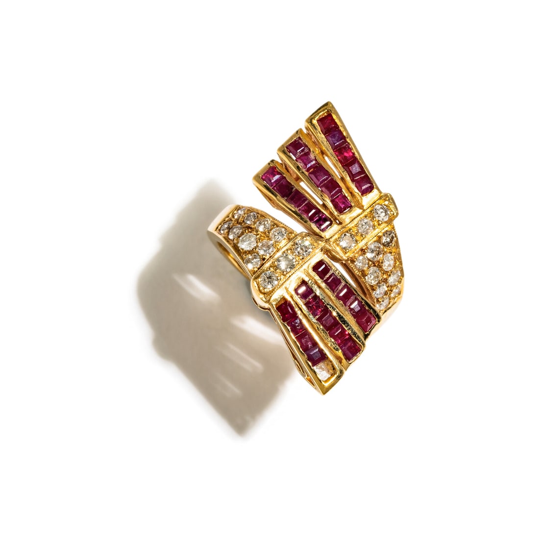 RUBY AND DIAMOND BY PASS RING: RUBY AND DIAMOND BY PASS RING Calibré-cut rubies and round diamonds weighing approximately 0.82 carats. Yellow gold. Ring size 5 3/4. Gross weight: 5.55 dwt. Property from a Private Collector