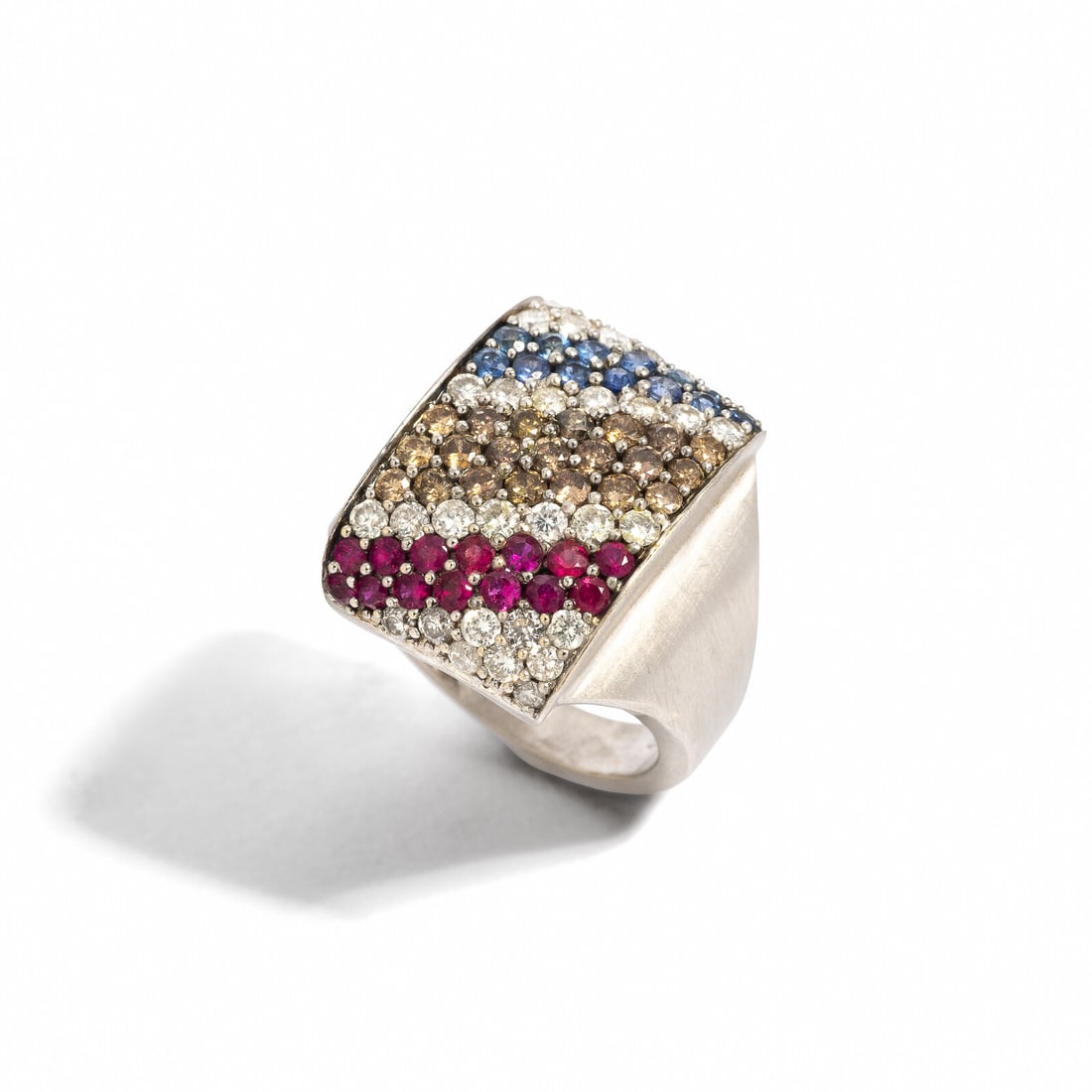 WHITE GOLD AND MULTIGEM RING: WHITE GOLD AND MULTIGEM RING Round rubies, round sapphires, and round diamonds and brown diamonds (origin of color not tested) weighing approximately 1.30 carats total. 18 karat yellow gold. Ring