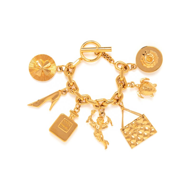 Chanel, Charm Bracelet: Chanel, Charm Bracelet Chain bracelet in gold-tone metal with dangling charms, featuring: a Chanel perfume bottle, a four-leaf clover medallion, a high heeled shoe, a cherub, a Chanel flap bag, a