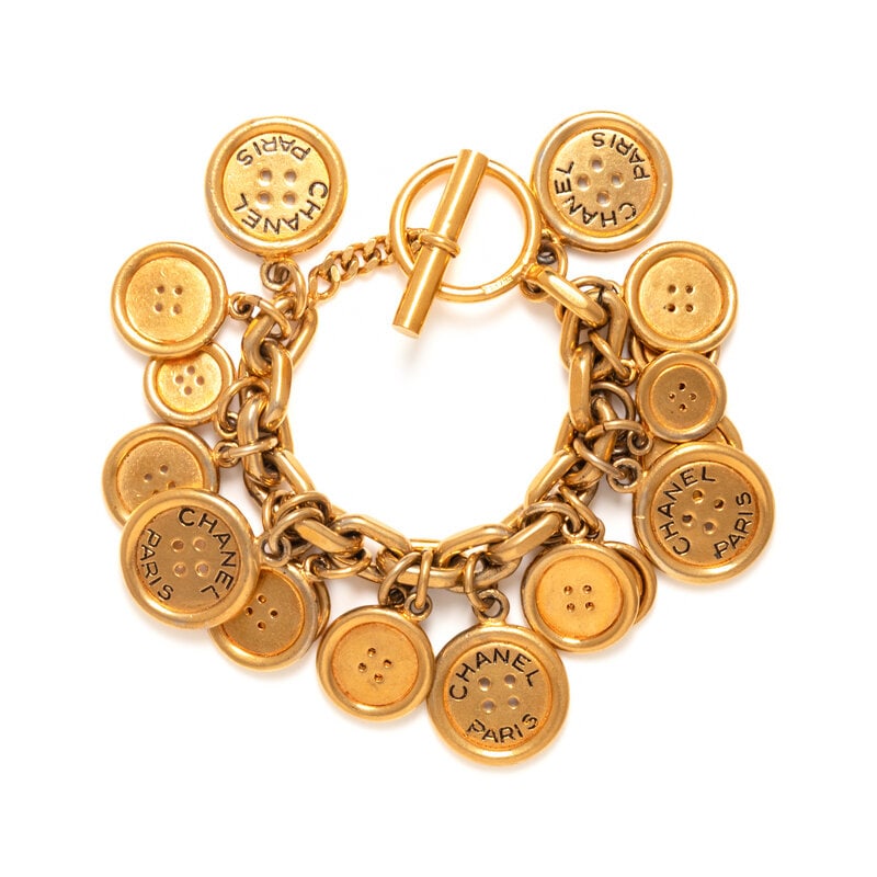 Chanel, Button Charm Bracelet: Chanel, Button Charm Bracelet Chain-link bracelet in gold-tone metal with button charms of various sizes. Toggle closure. Label: Chanel Date: Late 20th Century Country of Origin: France 