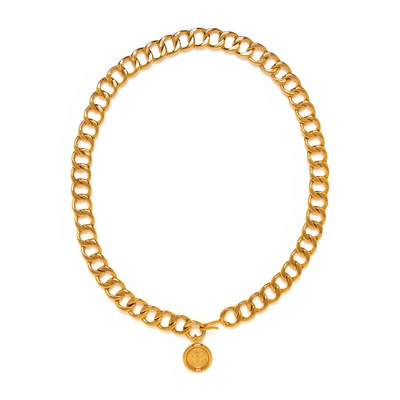Chanel, Medallion Chain Belt: Chanel, Medallion Chain Belt Cuban link chain belt in gold-tone metal. With adjustable hook closure and hanging medallion. Label: Chanel Date: 1980's Country of Origin: France Approximate