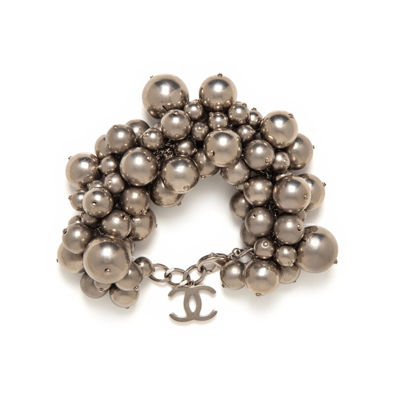 Chanel, Oversized Metal Bauble Bracelet: Chanel, Oversized Metal Bauble Bracelet Oversized bracelet in aged silver-tone metal; composed of clusters of various-sized baubles on a chain, with a dangling CC charm at the end. Lobster clasp