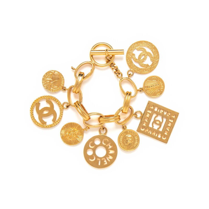 Chanel, Medallion Charm Bracelet: Chanel, Medallion Charm Bracelet Chain bracelet in gold-tone metal with dangling medallion and logo charms. Toggle & loop closure. Stamped with maker's marks at interior of chain link.<