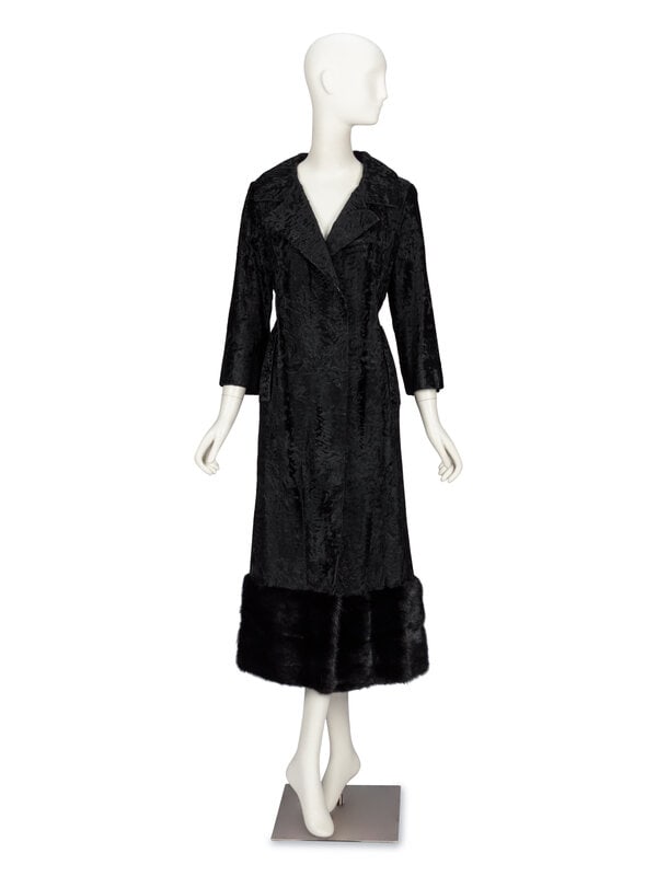 A Broadtail and Mink Coat : A Broadtail and Mink Coat Seven-eighths length coat in black broadtail fur with a wide band of black mink fur trim at hem. Open-front with two belt holes; with removable black leather belt