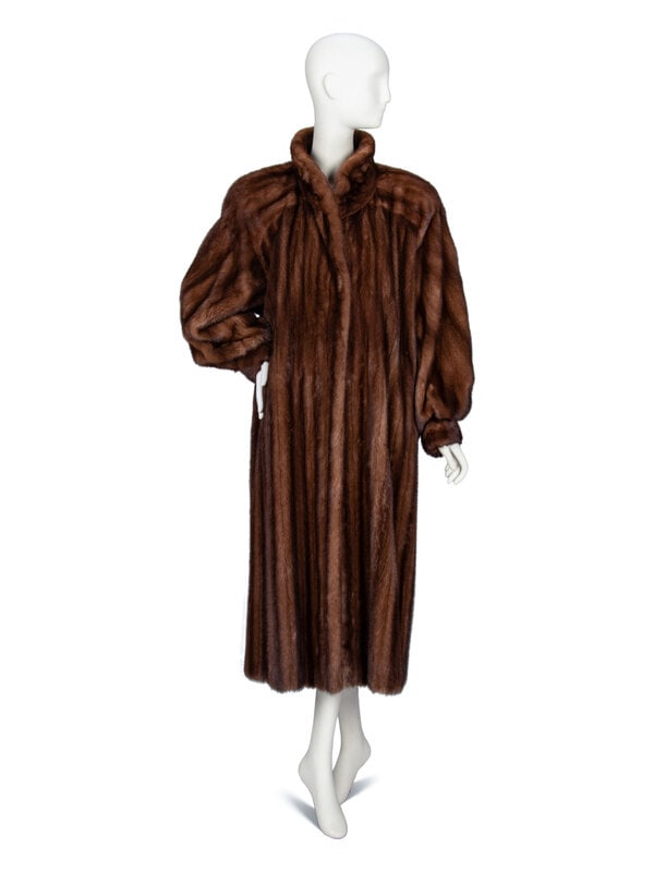 Galanos, Long Mink Fur Coat: Galanos, Long Mink Fur Coat Seven-eighths length fur coat in brown mink fur. Convertible stand/rounded spread collar. Padding at shoulders. Full-length raglan bishop sleeves with cuffs. Two