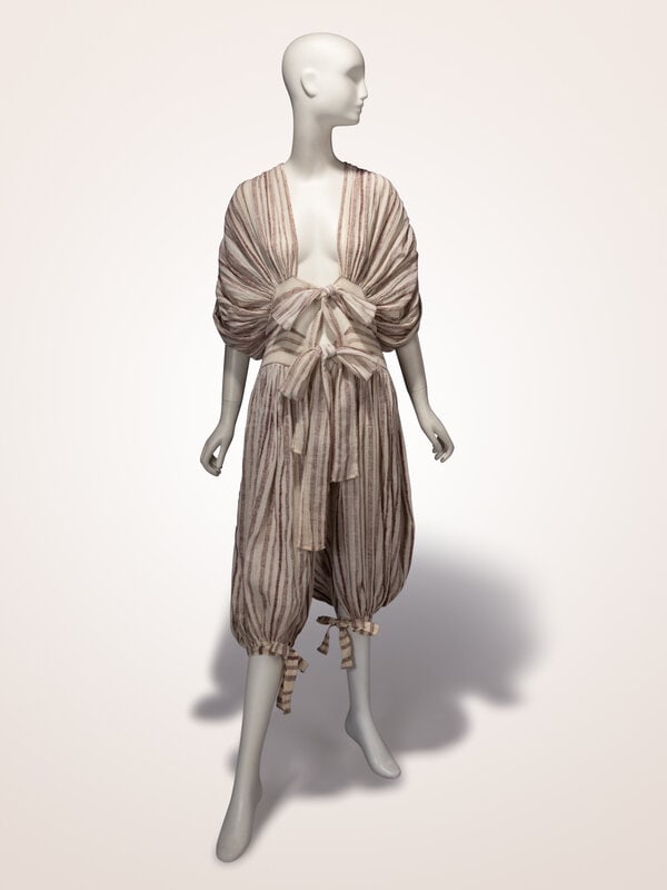 Norma Kamali, Striped Linen Jumpsuit, 1970s : Norma Kamali, Striped Linen Jumpsuit, 1970s Jumpsuit in beige and brown-striped rugged linen. Open front to crotch with tie closures at waistband. Draped & ruched bodice panels/dolman-