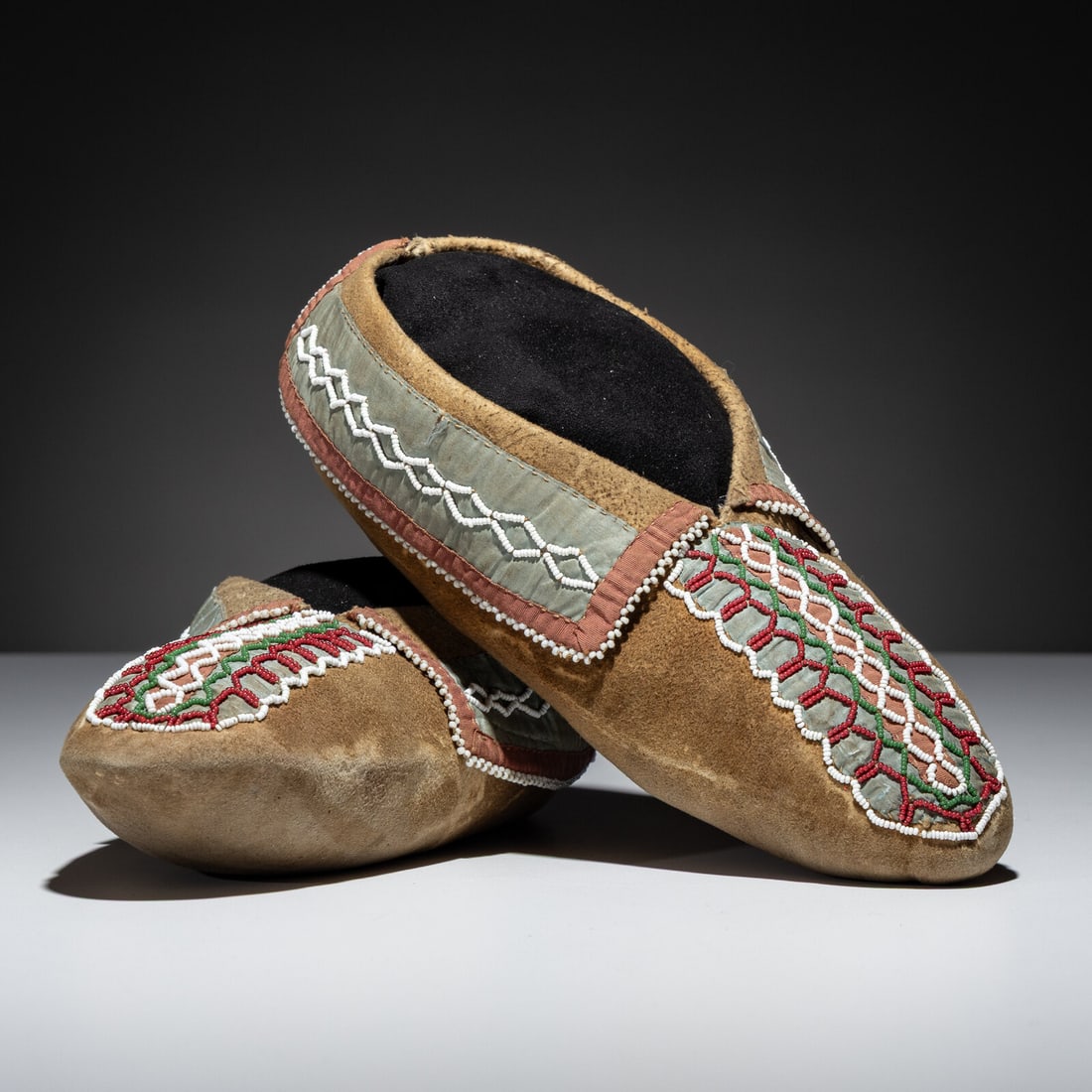 Northeastern Woodlands Beaded Hide Moccasins: Northeastern Woodlands Beaded Hide Moccasins early 19th century thread and sinew-sewn; beaded pattern of classic power imagery with colors of red white-heart, white, and pea green; silk ribbon 