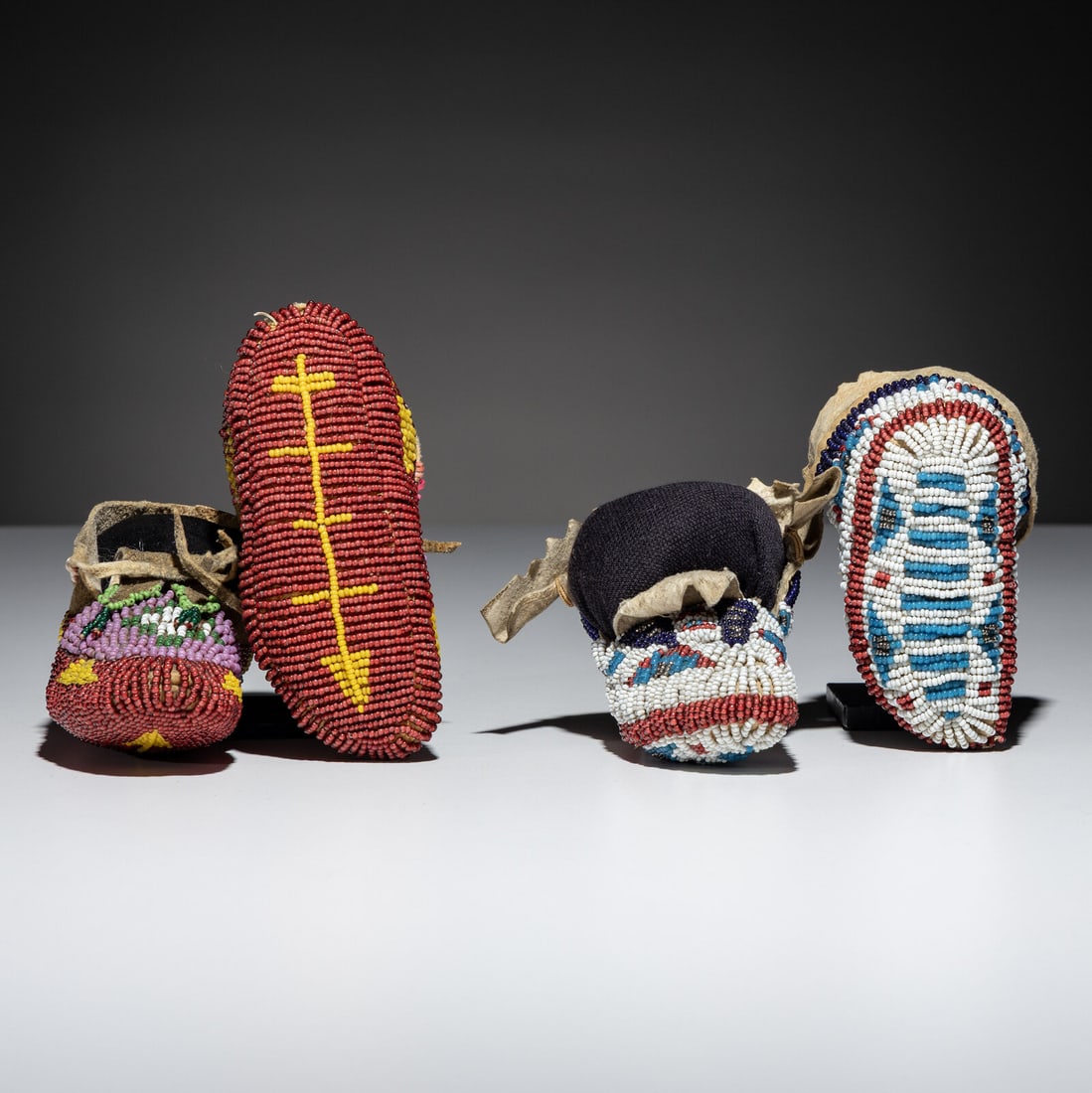 Plains Child's Fully Beaded Hide Moccasins: Plains Child's Fully Beaded Hide Moccasins fourth quarter 19th century lot of 2, includes: a Central Plains pair beaded with colors of red white-heart, pink, pea green, light green, and greasy
