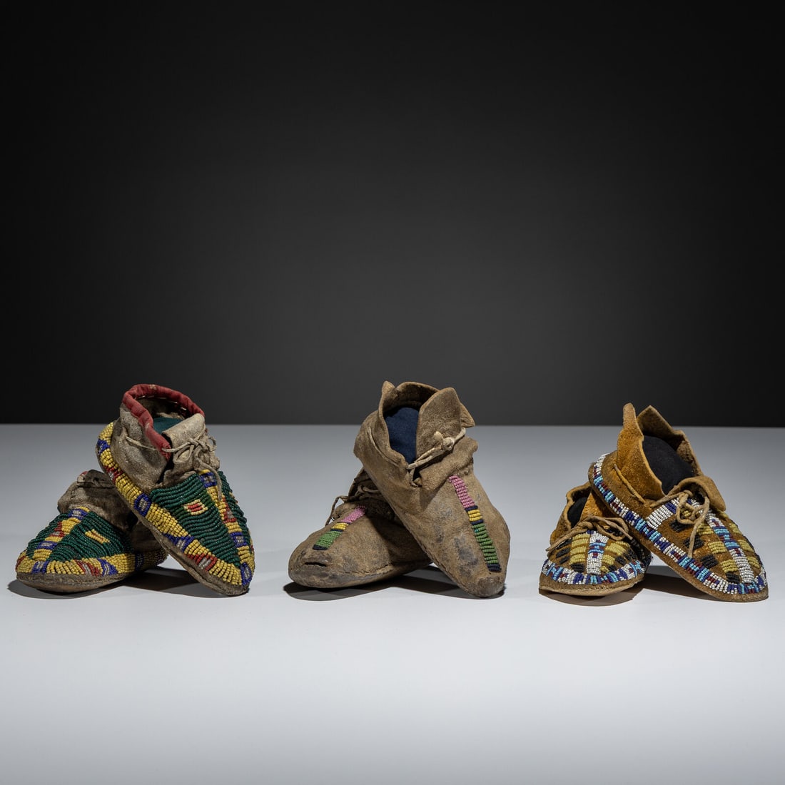 Plains Child's Beaded Hide Moccasins: Plains Child's Beaded Hide Moccasins fourth quarter 19th century lot of 3, includes: a Sioux pair, sinew-sewn on hide; beaded on vamps and along the sides; length 5-1/4 inches a Cheyenne pair,