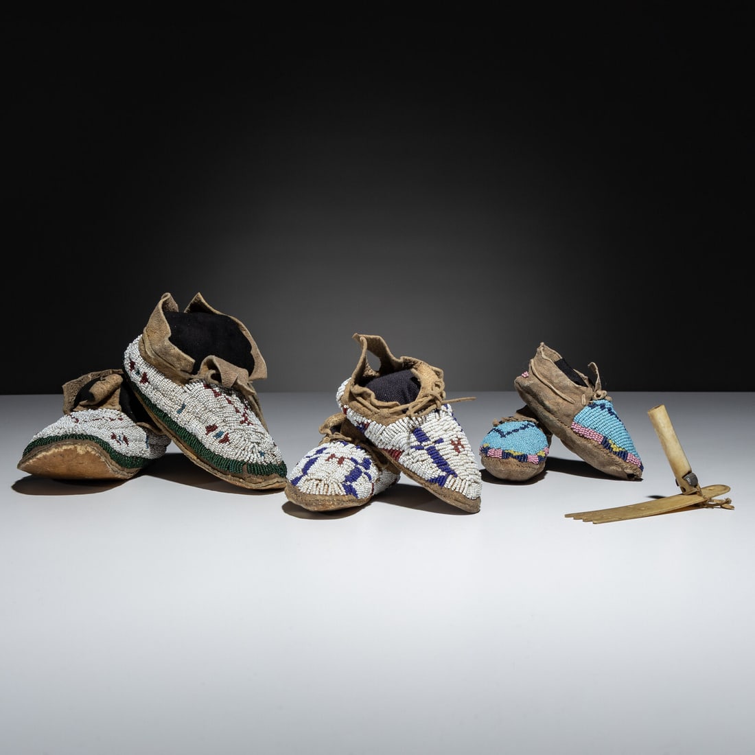 Plains Child's Beaded Hide Moccasins, and Roach Spreader: Plains Child's Beaded Hide Moccasins, and Roach Spreader late 19th century lot of 4, includes: a Cheyenne pair of buffalo hide moccasins, sinew-sewn and beaded in colors of translucent green, rose,