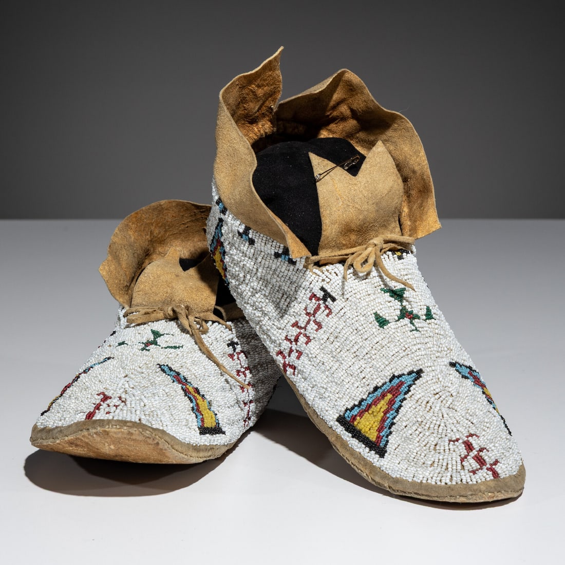 Cheyenne Beaded Hide Moccasins, with Thunderbirds: Cheyenne Beaded Hide Moccasins, with Thunderbirds fourth quarter 19th century sinew-sewn; beaded on a white ground in colors of sky blue, cobalt, red white-heart, translucent green, and greasy yellow