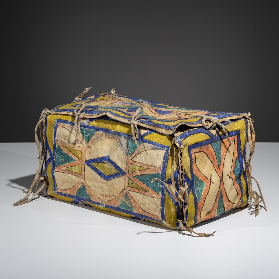 Sioux Painted Parfleche Box: Sioux Painted Parfleche Box late 19th century brightly painted on five sides in blues, yellow, and red with a diamond and hourglass motif height 7-3/4 inches x length 15 inches x width 9 inches From
