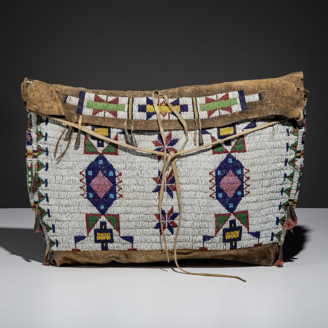 Sioux Beaded Hide Possible Bag: Sioux Beaded Hide Possible Bag fourth quarter 19th century sinew-sewn and beaded with geometric elements in colors of navy blue, sky blue, greasy pink, red white-heart, yellow, jade green, white, and