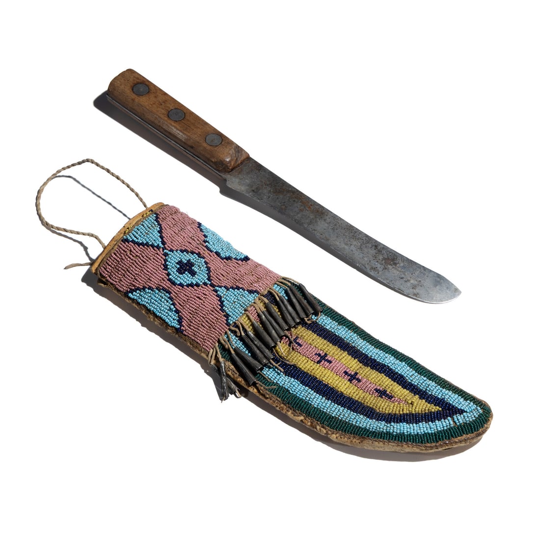 Sioux Beaded Buffalo Hide Knife Case: Sioux Beaded Buffalo Hide Knife Case third quarter 19th century sinew-sewn and beaded with colors of pink, light blue, cobalt, translucent green, and greasy yellow; tin cone fringe; rawhide lined 