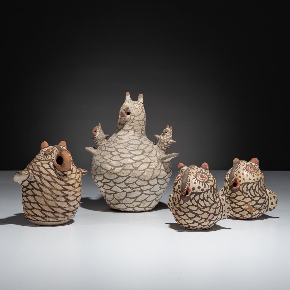 A Parliament of Zuni Pottery Owls: A Parliament of Zuni Pottery Owls first half 20th century lot of 4, includes: a larger storyteller example, with two owlets height 8-3/4 inches x diameter 7-1/2 inches a matching pair height 4-3/8