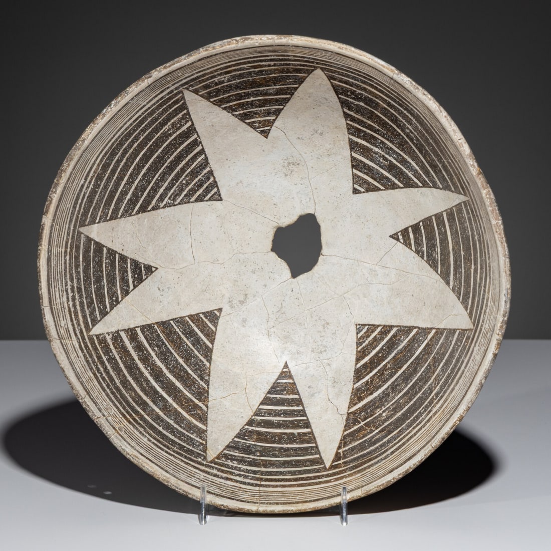 Ancestral Pueblo, Mimbres Classic Black-on-White Pottery Bowl, with Star or Blossom Design: Ancestral Pueblo, Mimbres Classic Black-on-White Pottery Bowl, with Star or Blossom Design A.D. 1000-1140 height 4-3/8 inches x diameter 10-7/8 inches From an Old Hollywood Family This lot is