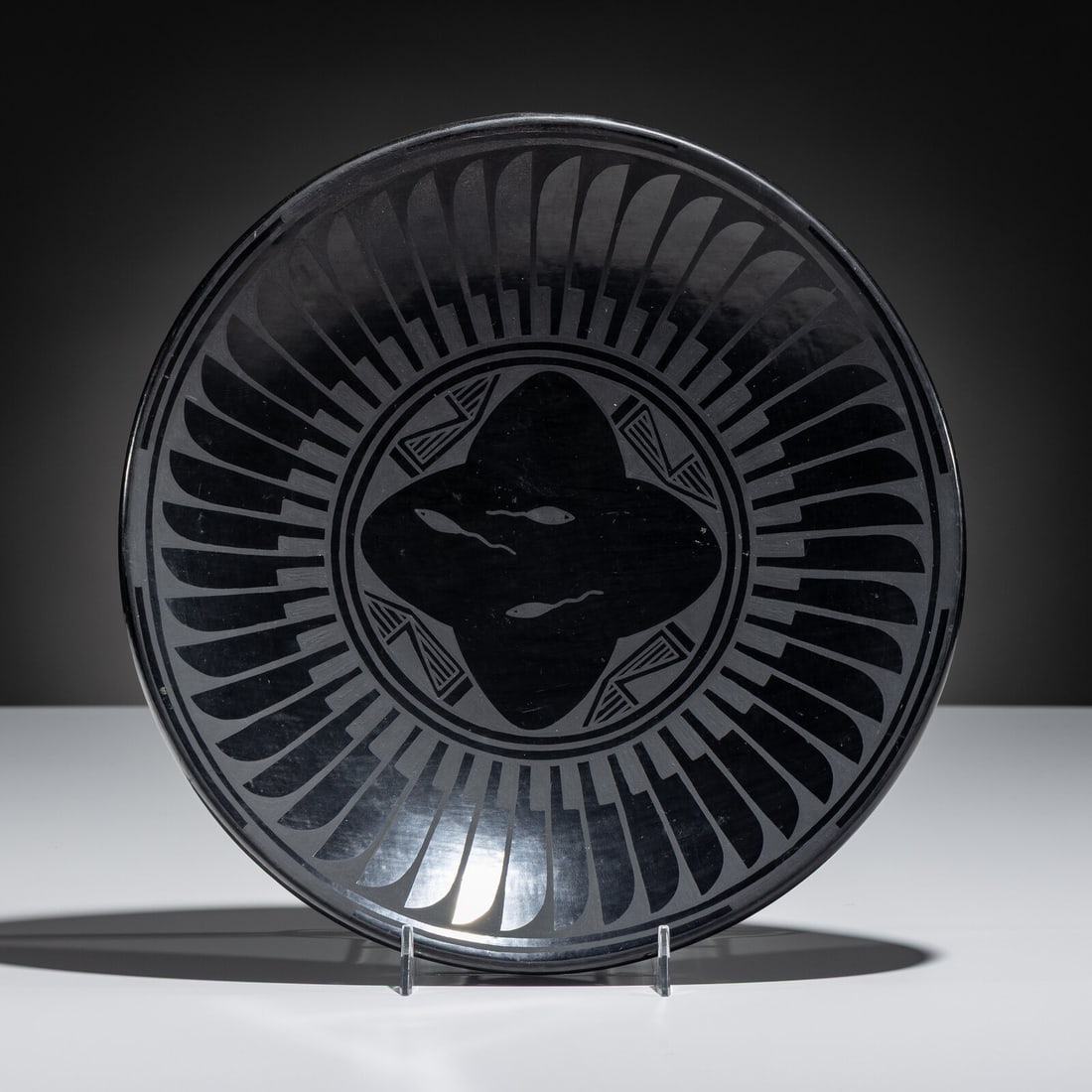 Crucita Calabaza, Blue Corn (San Ildefonso, 1921-1999) Blackware Pottery Plate: Crucita Calabaza, Blue Corn (San Ildefonso, 1921-1999) Blackware Pottery Plate repeating feather design, with fish in central medallion; signed on base height 2 inches x diameter 11 inches Property fr