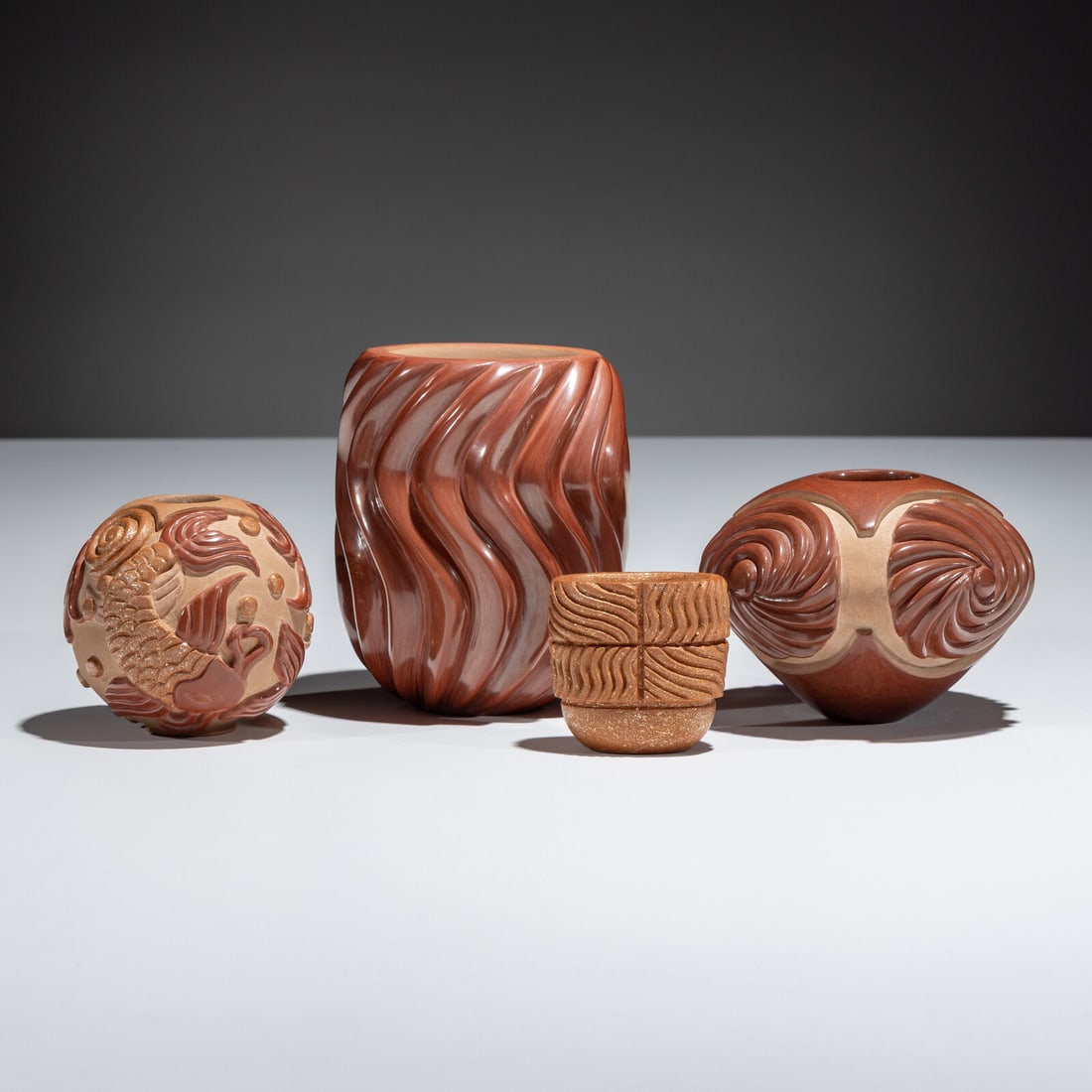 Nancy Youngblood AND Chris Youngblood (Santa Clara, b. 1955 / b. 1989) Red and Tan Carved Pottery: Nancy Youngblood AND Chris Youngblood (Santa Clara, b. 1955 / b. 1989) Red and Tan Carved Pottery lot of 4, includes: a redware swirl jar by Nancy Youngblood; 16 ribs; signed on base, height 4-1/4 inc
