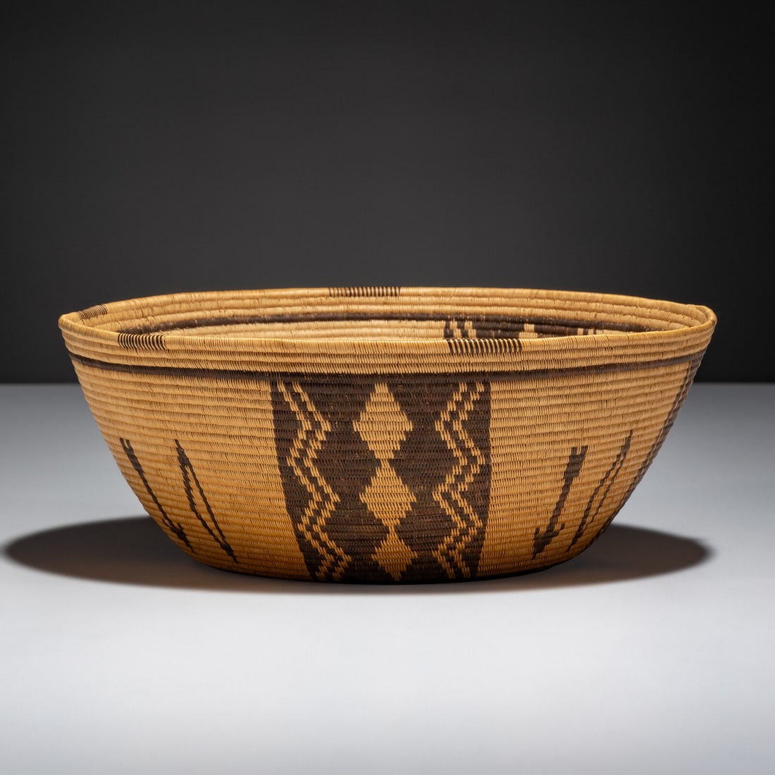 Paiute Pictorial Basket: Paiute Pictorial Basket early 20th century finely woven and designed with bows and arrows height 3-1/2 inches x diameter 9 inches Property from the Collection of Dr. Deane and Susan Penn This lot is